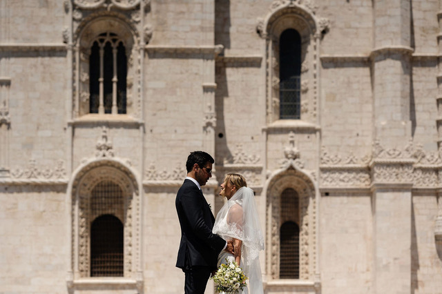 Bride and groom in front of a stone church in Portugal
