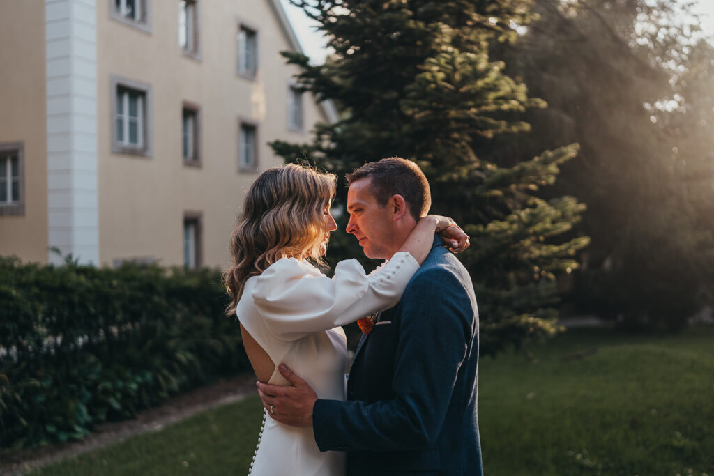 Couple embracing outdoors, sunlight on their faces