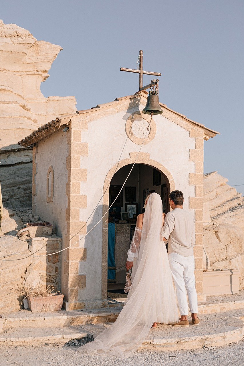 Couple entering a small church on a cliffside