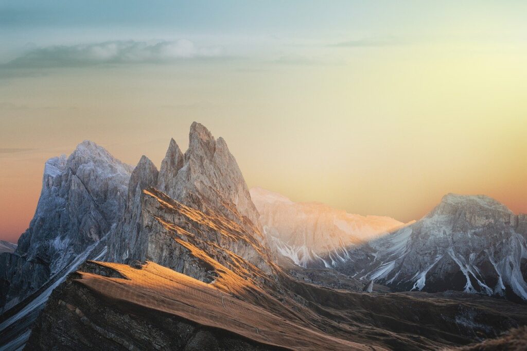 Mountain peaks at sunset, with warm light on slopes.