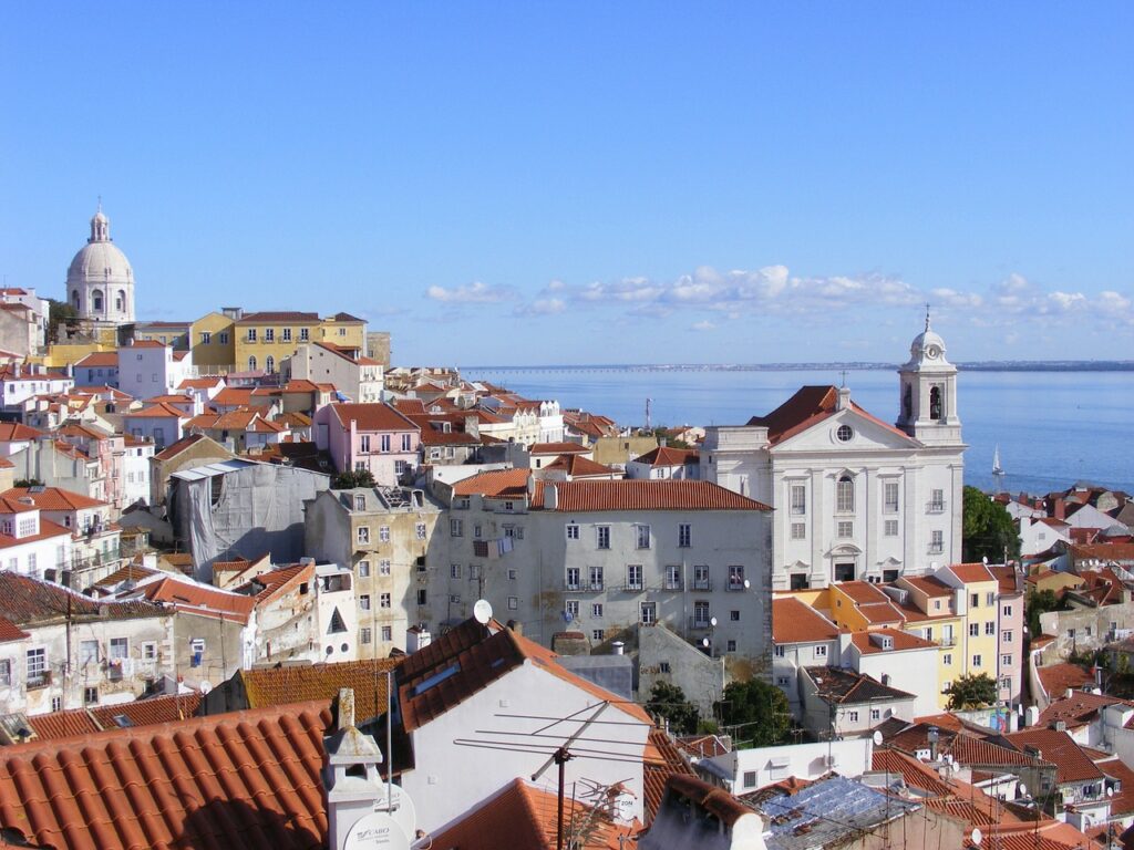 Cityscape of Lisbon, Portugal, with a river and blue sky