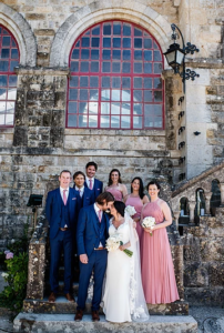 Wedding party on stone steps, bride and groom in front