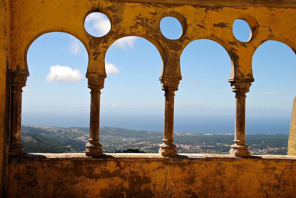 Arched balcony overlooking a town and ocean