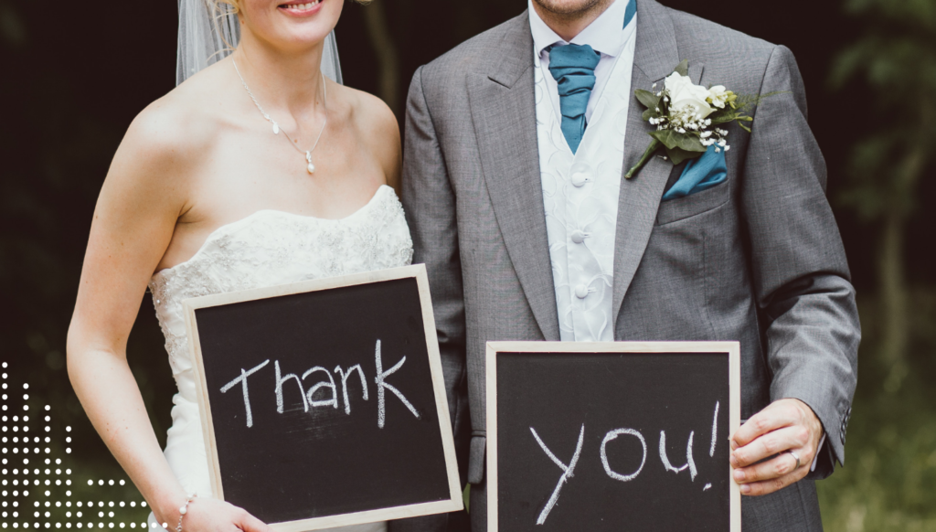 Bride and groom holding 'Thank You!' signs