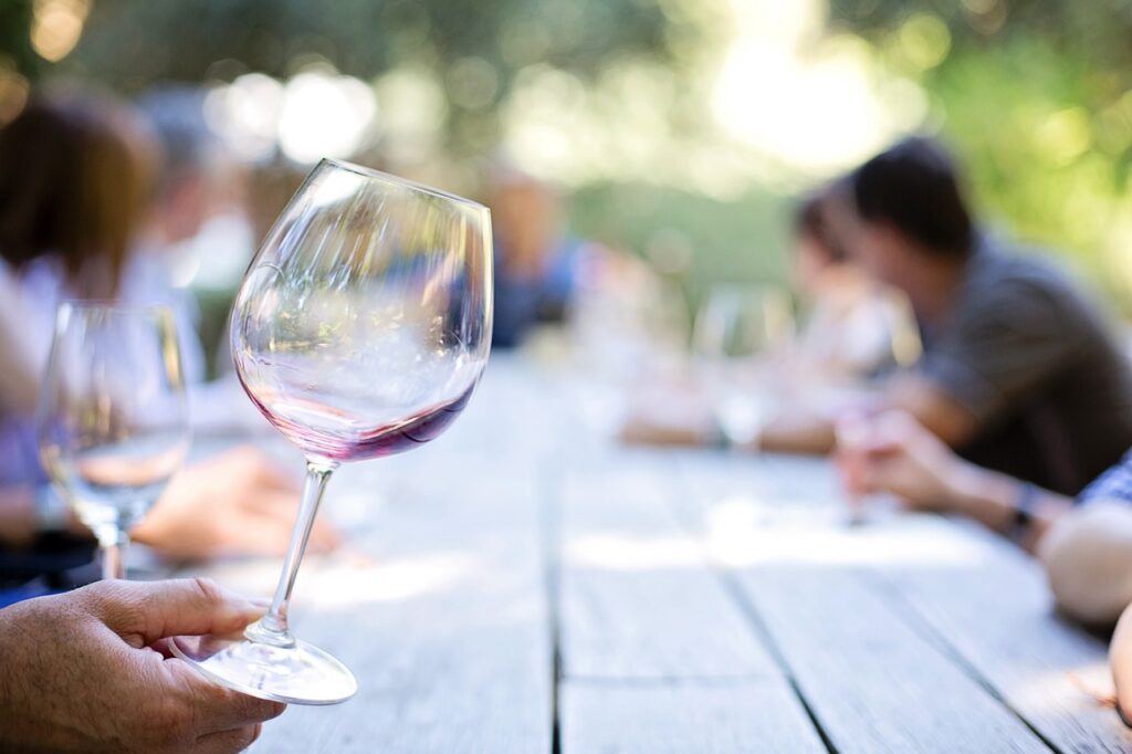 Hand holding a wine glass with a little red wine left